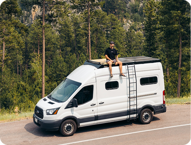 Une personne voyage dans un camping-car équipé de panneaux solaires sur le toit.